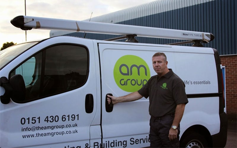 AM Group plumbing and heating engineer stood in front of AM Group van