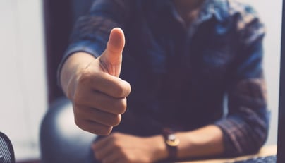 Man holding thumb up to show positivity